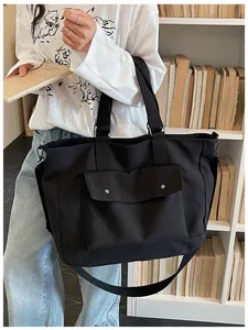Lifestyle view of a large black canvas tote bag with adjustable shoulder strap