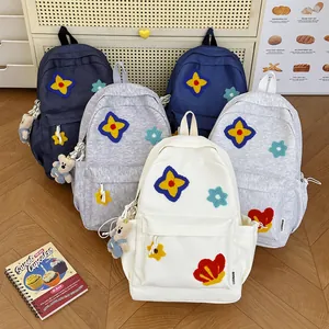 Multiple colors of cute school backpacks with floral patches and teddy bear charms shown together