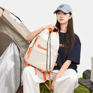 Sac à dos blanc et orange à cordon dans un décor de camping en plein air très élégant