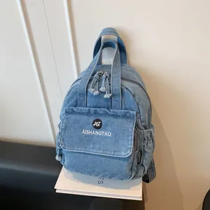 Nahaufnahme eines stylischen Denim-Minirucksacks für Damen mit besticktem Frontlogo