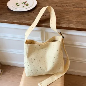 Detail of a minimalist light yellow canvas tote bag with shiny star print patterns