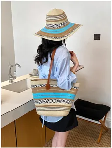 Lifestyle-Ansicht einer großen gewebten Stroh-Strandtasche mit passendem Sonnenhut