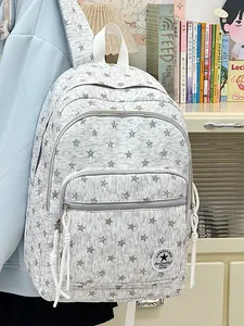 Detailed view of grey star-patterned backpack with multiple compartments for students.