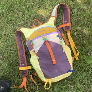 Detail view of colorful lightweight outdoor hiking backpack placed on green grass