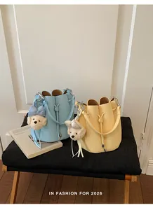 Detailed close-up of stylish pebbled leather bucket bags in light blue and yellow