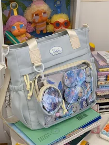 Close-up detail of a light blue Ita bag with a transparent display pocket for anime badges