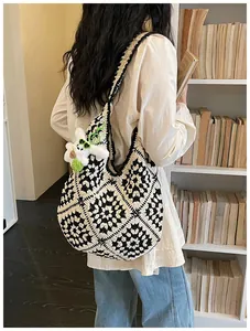 Primo piano di borsa tote lavorata all'uncinetto in bianco e nero con ciondolo a coniglio.