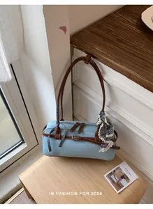 Detail view of the light blue Boston bag with brown contrast straps and decorative scarf.