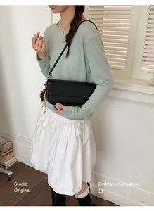 Minimalist black underarm shoulder bag for women shown in a lifestyle studio shot