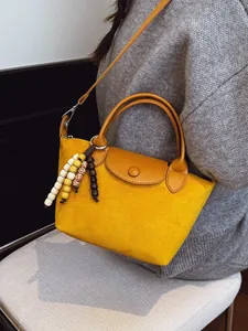 Sac à main jaune élégant pour femme avec bandoulière marron et gland de perles chic