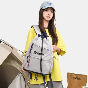 Sac à dos à cordon gris fonctionnel et élégant présenté par un mannequin dans un campement