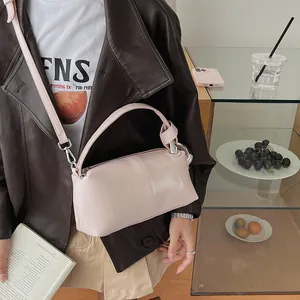 Detail shot of a pink retro pillow handbag with a stylish leather jacket outfit.