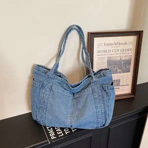 Grand sac cabas en denim bleu avec plusieurs poches extérieures dans un beau décor