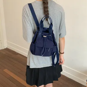 Primer plano de una mochila azul marino con cordón usada como una vista de detalle.