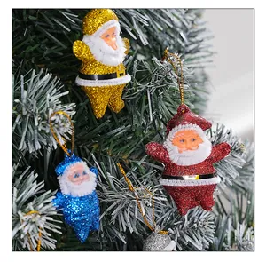 Detailed macro shot of colorful glittery Santa Claus ornaments hanging on a frosted Christmas tree.