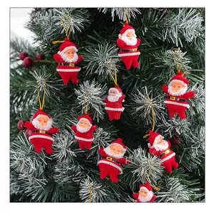 Detailed view of red flocked Santa Claus ornaments hanging on a festive Christmas tree