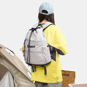 Sac à dos léger gris à cordon pour l'extérieur montré dans un cadre de camping de style