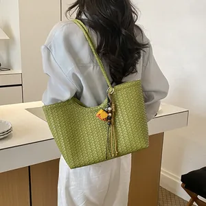 Vista trasera de una mujer que lleva un bolso tote tejido verde lima en una cocina