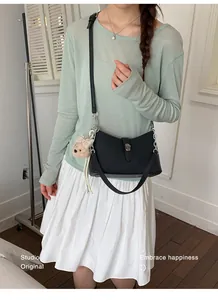 Vista dettagliata di una borsa sottobraccio nera chic indossata da una modella
