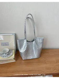 Close-up of elegant silver woven tote bag on a minimalist wooden desk scene