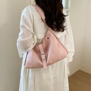Back view of pink fashionable hobo shoulder bag with buckle detail on white trench coat
