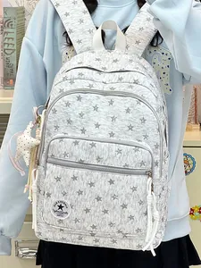Close-up of grey star pattern backpack for school girls with large capacity and cute keychain