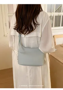 Minimalist leather shoulder bag detail shot highlighting soft texture and sleek underarm hobo style.