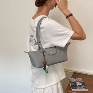 Sac sous l'aisselle de style coréen gris porté par un mannequin dans un décor lifestyle