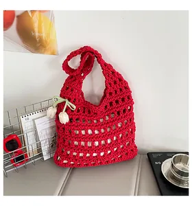 Primer plano de un bolso de hombro de punto calado rojo con decoración de flores