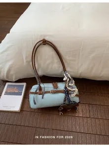 Light blue textured Boston bag with brown contrast straps and decorative charms