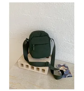 Stylish dark green nylon crossbody phone bag featuring a minimalist design and adjustable strap