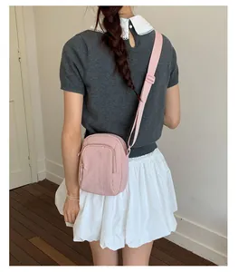 Stilvolle rosa Mini-Umhängetasche für Damen, gezeigt an einem Model im schlichten Stil