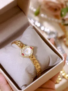 Elegante reloj de cadena vintage dorado con bisel de estrás y detalles de cristal rojo