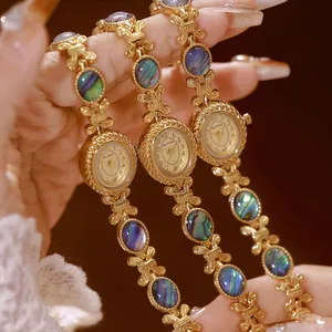 Detalle de relojes de pulsera dorados con piedras naturales de concha de abulón