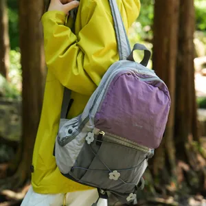 Outdoor-Wanderrucksack mit lila und grauem Farblock-Design in waldiger Umgebung