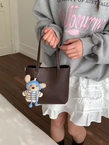Elegant brown lychee grain leather bucket bag with cute teddy bear charm for women
