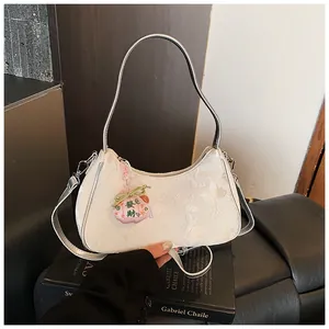 Detail of white butterfly jacquard crescent bag with a traditional fortune lucky charm.