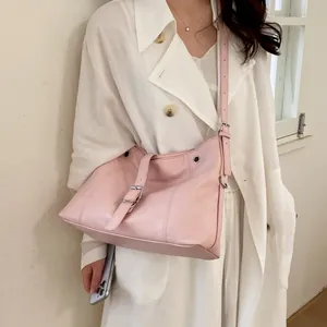 Detail view of pink leather shoulder bag featuring adjustable strap and buckle