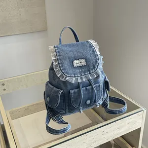 Vista dettagliata dello zaino vintage in denim con eleganti volant in pizzo bianco e ricami