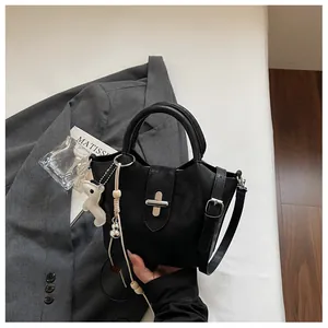 Gros plan d'un sac seau noir élégant avec une boucle et un porte-clé de cheval
