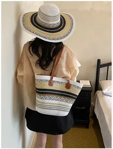 Stilvolles Set aus großer Strohtasche und Sonnenhut für den Sommerurlaub am Strand.