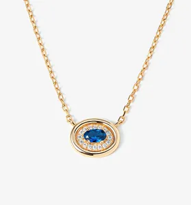 Detailed close-up of an elegant gold plated S925 silver necklace with a blue oval gemstone