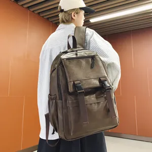 Vue arrière détaillée d'un grand sac à dos vintage en cuir marron sur un modèle en milieu urbain