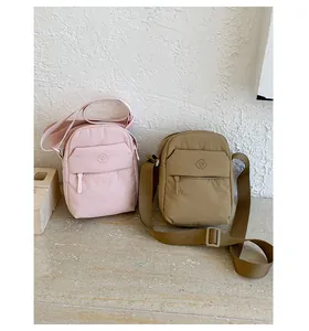 Small minimalist nylon crossbody bags in pink and khaki colors with adjustable straps.