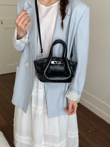 Borsa a secchiello nera minimalista da donna con elegante chiusura metallica e tracolla