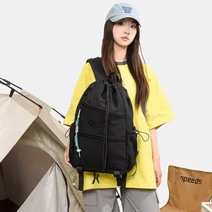 Vue détaillée d'un sac à dos noir à cordon polyvalent dans un décor de camping.