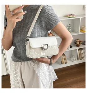 Detailansicht einer weißen quadratischen Umhängetasche mit Marmormuster an einem Model.