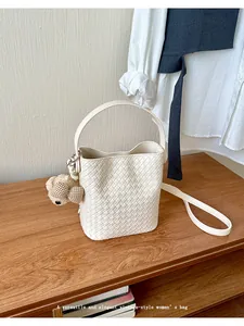 Detailed shot of white woven bucket bag with elegant vintage texture