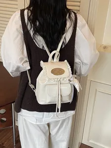 Elegante witte mini-rugzak met kanten afwerking en een stijlvol metalen plaatjesdetail
