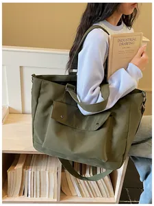 Close-up of a large olive green nylon tote bag carried by a model